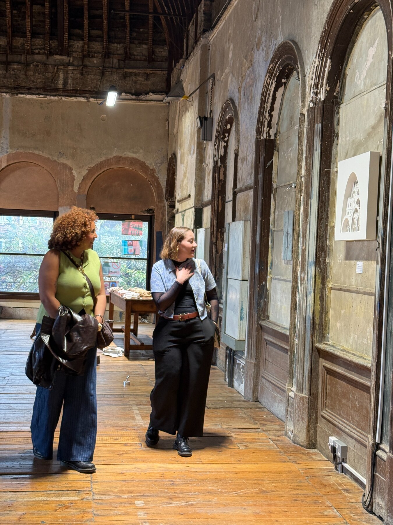 Besucherinnen betrachten die Ausstellung im Old Waiting Room